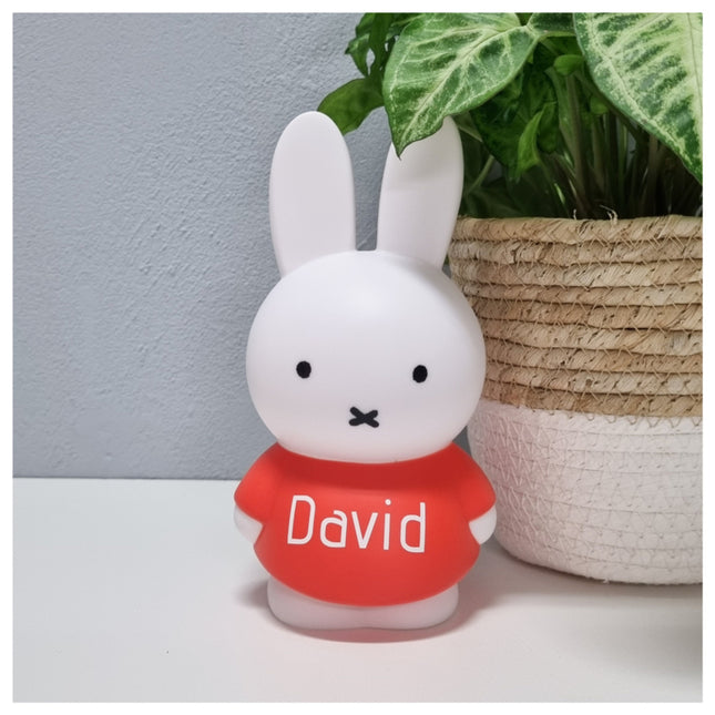 Een Nijntje spaarpot met naam in wit met rood. Een gepersonaliseerd kraamcadeau