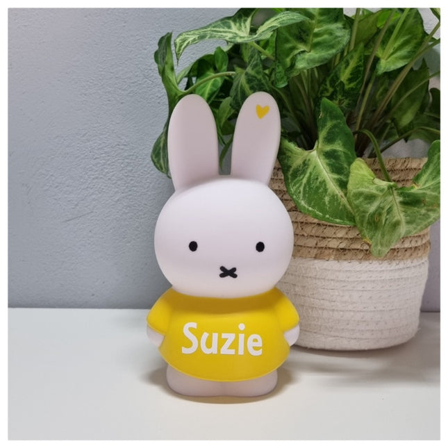 Een Nijntje spaarpot met naam; in wit met geel shirtje. Zo'n Nijntje met naam is een leuk kraamcadeau