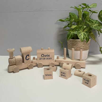 Houten bouwtrein met naam, datum en bouw blokken met afmetingen erop