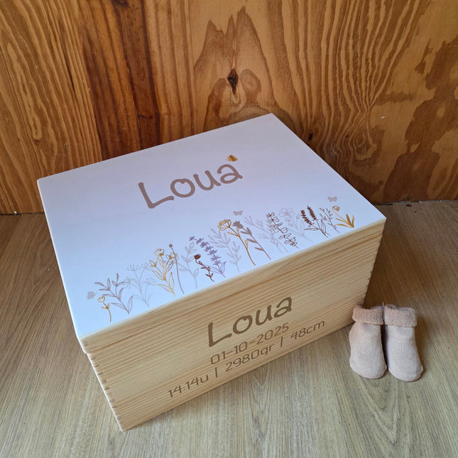 Een naturel houten herinneringskist met naam en wilde bloemen erop