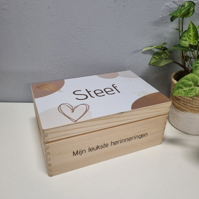Een prachtige houten herinneringskist met een grafisch design en de naam erop. 