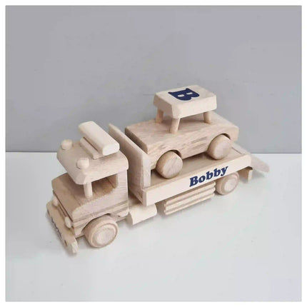 Houten sleepwagen met een auto erop en naam en datum