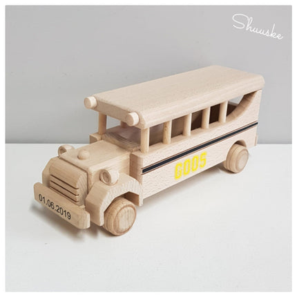 Houten schoolbus met datum in de zwart op de voorkant en naam in het geel op de zijkant