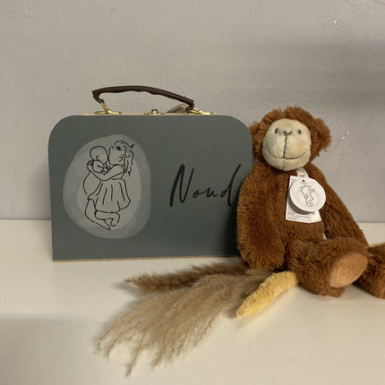 Een kinderKoffertjes met naam en daarnaast is er een knuffel
