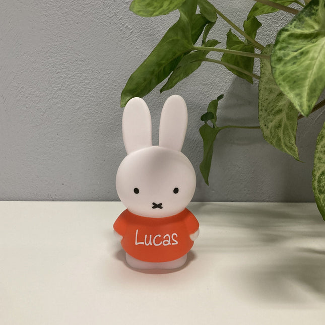 Een kleine Nijntje spaarpot met naam in wit met rood. Deze Nijntje met naam is een gepersonaliseerd cadeau