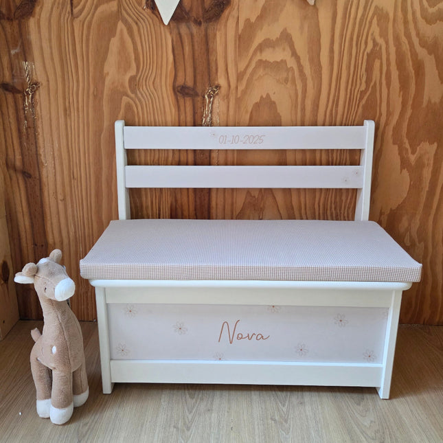 Een wit houten opbergbankje met naam en leuke bloemetjes erop
