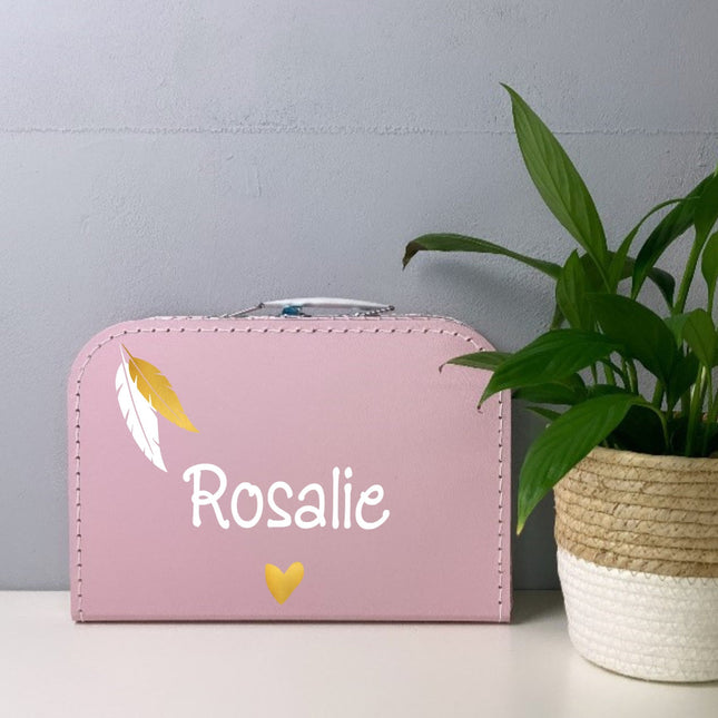 Een roze koffertje met naam en goud veertjes 